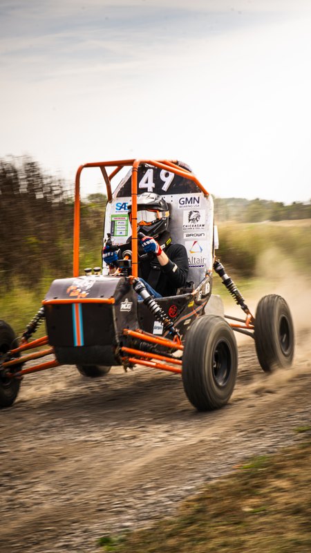 Orange ONU Baja SAE car number 49 testing on a dirt and gravel course