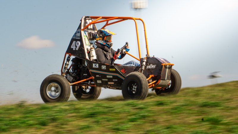 Orange ONU Baja SAE car number 49 testing on a dirt course