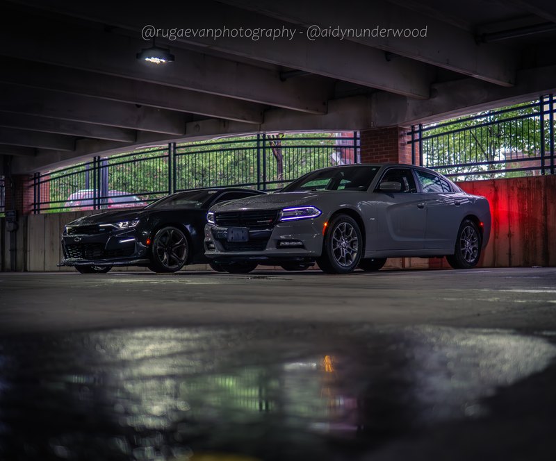 Dark muscle car in a concrete parking garage at night