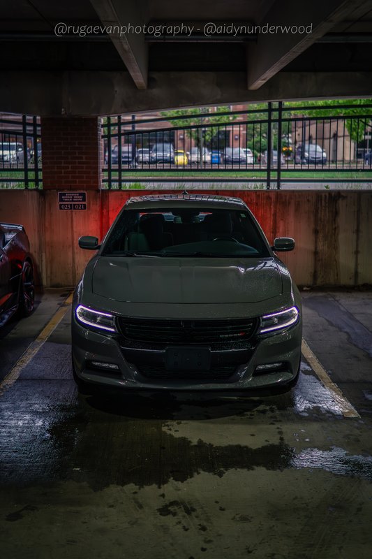 Dark muscle car in a concrete parking garage at night
