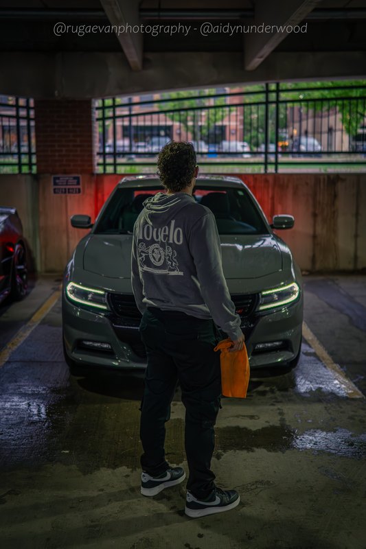 Dark muscle car in a concrete parking garage at night