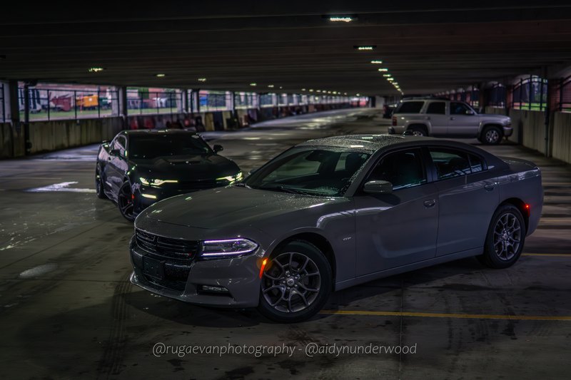 Dark muscle car in a concrete parking garage at night
