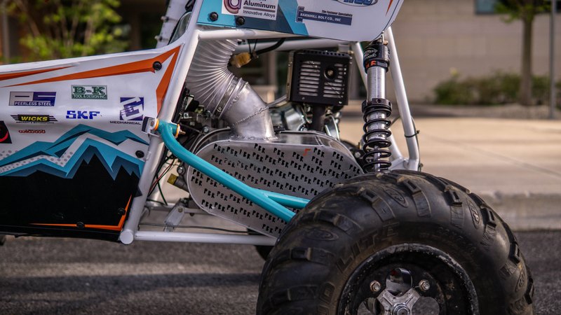 ONU Baja SAE car number 32, white bodywork and teal frame, at its reveal shoot