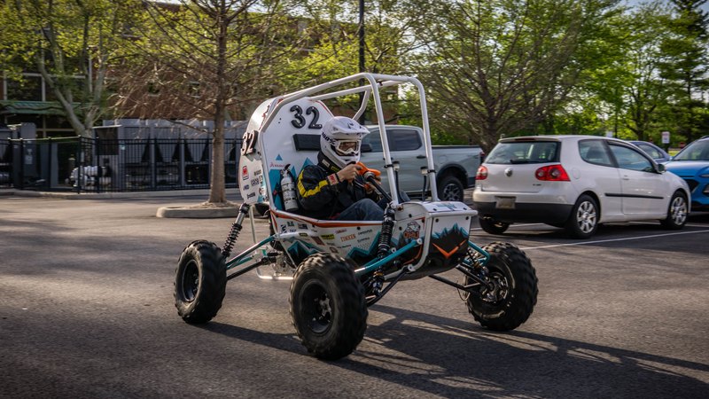 ONU Baja SAE car number 32, white bodywork and teal frame, at its reveal shoot