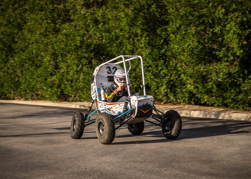 ONU Baja SAE car number 32, white bodywork and teal frame, at its reveal shoot