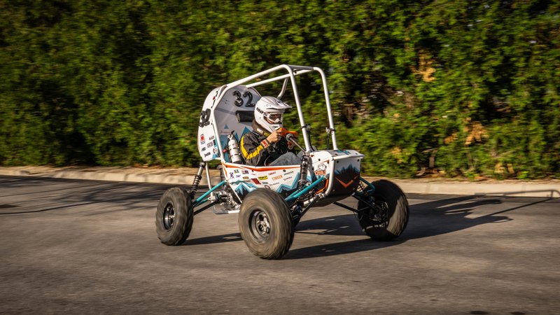 ONU Baja SAE car number 32, white bodywork and teal frame, at its reveal shoot