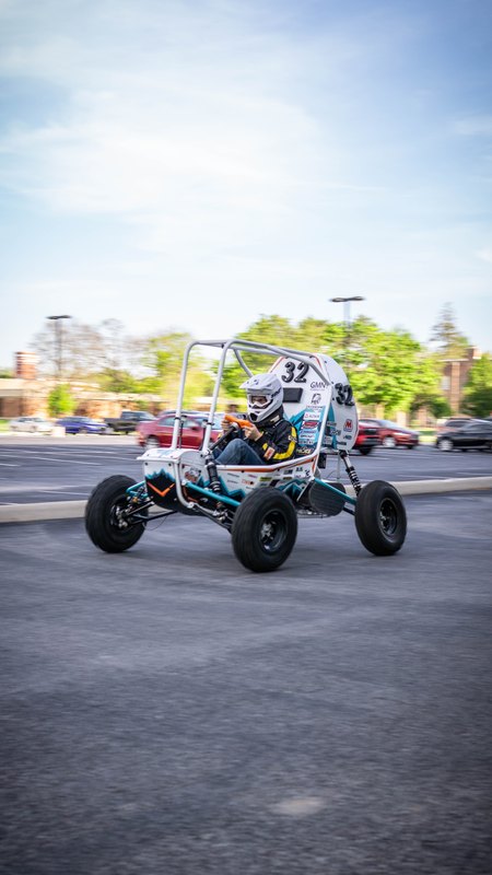 ONU Baja SAE car number 32, white bodywork and teal frame, at its reveal shoot