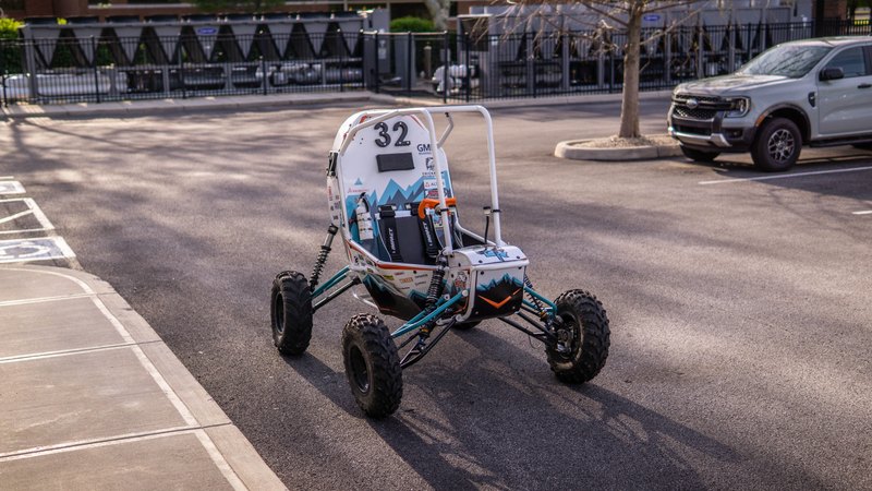 ONU Baja SAE car number 32, white bodywork and teal frame, at its reveal shoot