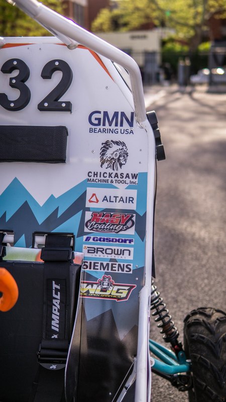 ONU Baja SAE car number 32, white bodywork and teal frame, at its reveal shoot